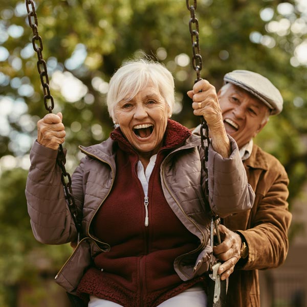 senior couple laughing at swingset