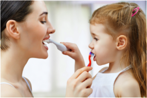 Mother and daughter brushing each other's teeth