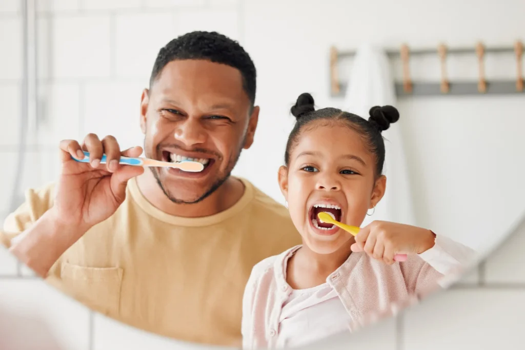 Father and daughter brushing their teeth together in Arlington Heights, IL