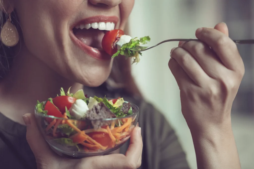 Woman eating a fresh salad as part of a healthy dental diet in Arlington Heights, IL